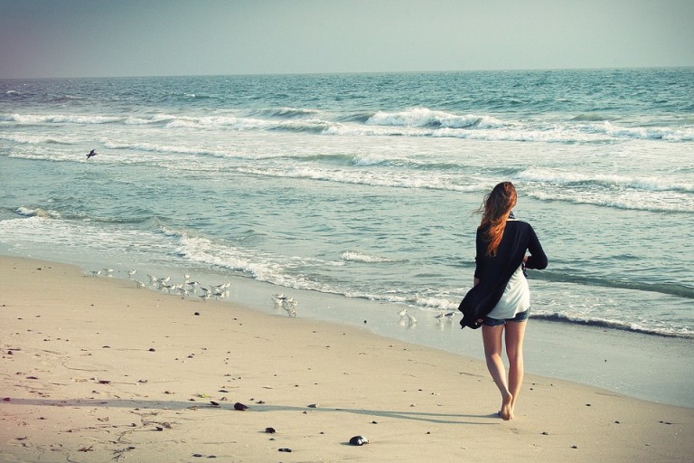 Frau am Strand mit enthaarten Beinen
